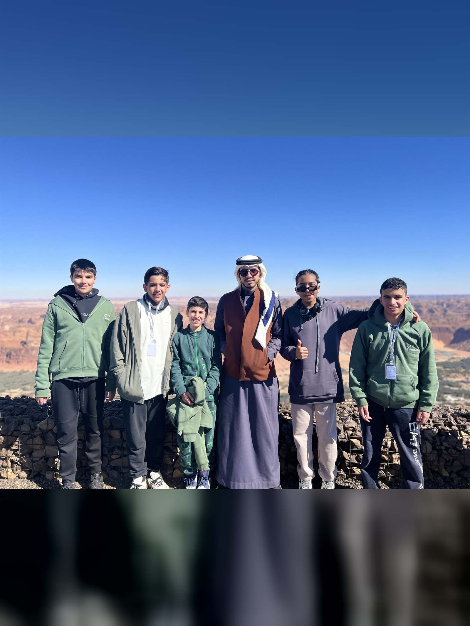 طلاب يقفون على حافة وادٍ صخري في العلا